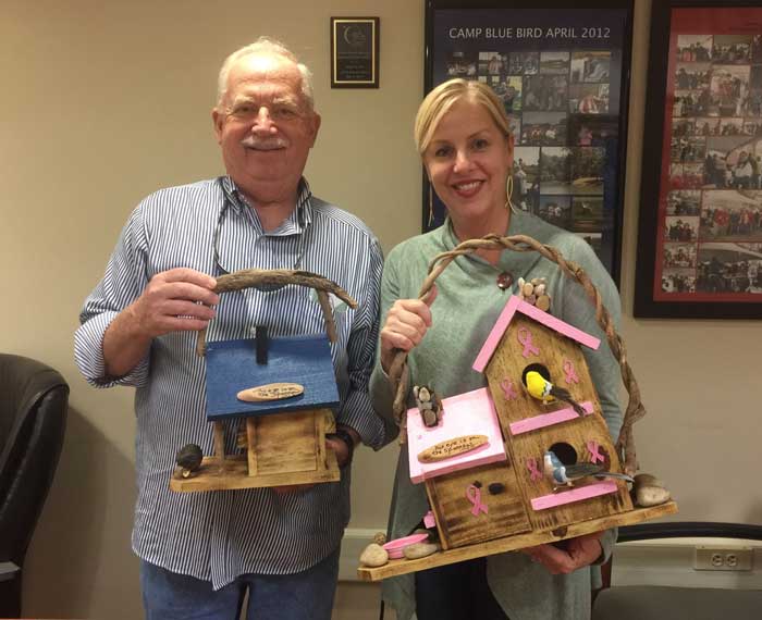 father and daughter holding birdhouse in hand