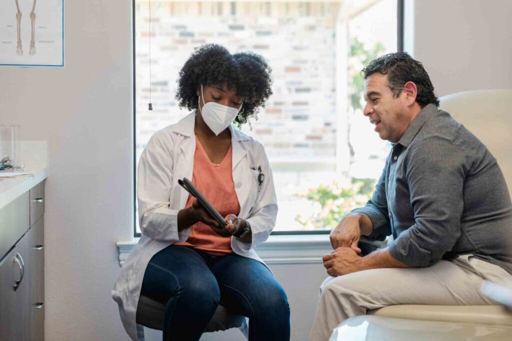 Female African American doctor discussing cancer risks with male patient